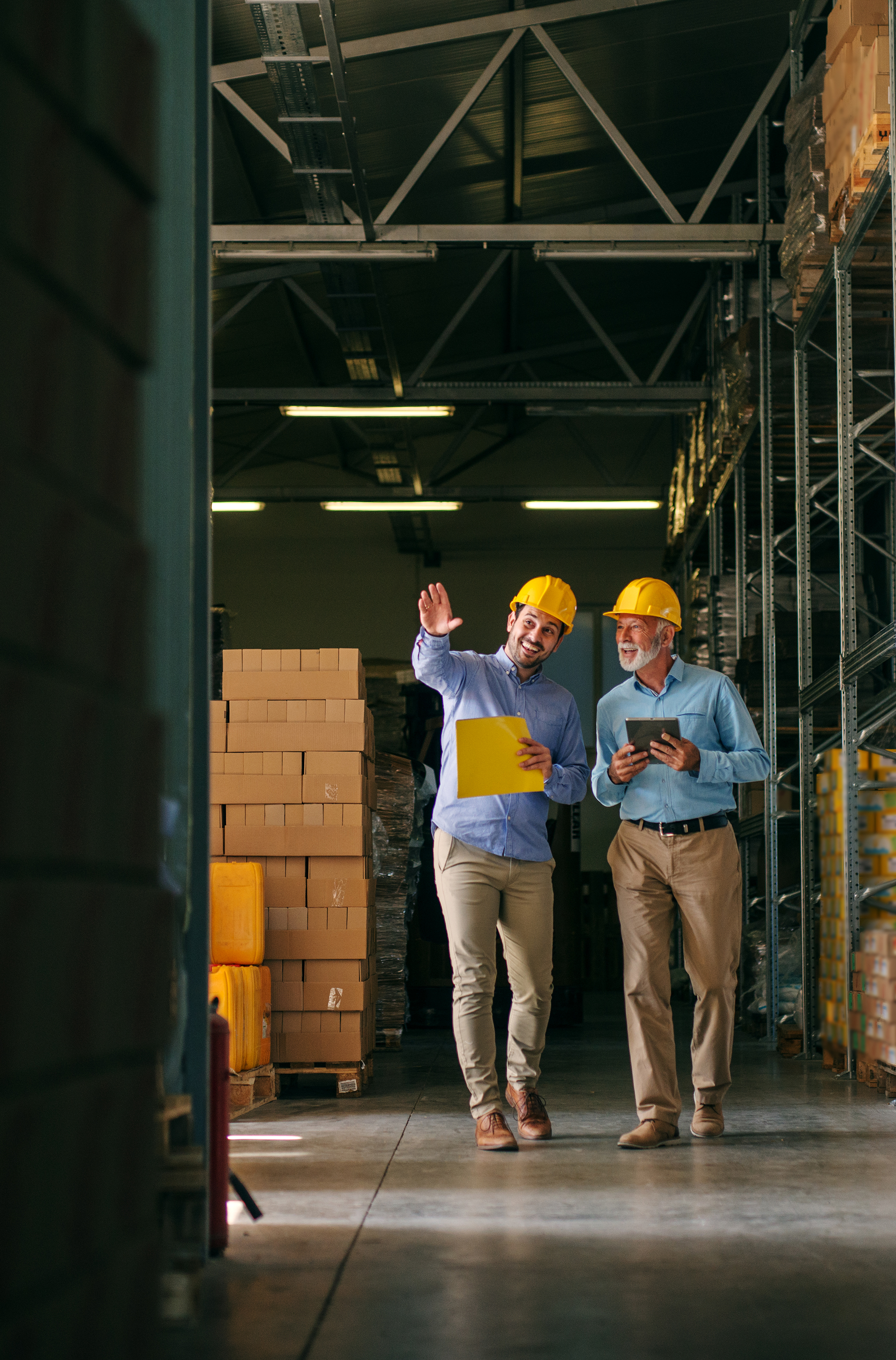 Two men walking through big warehouse
