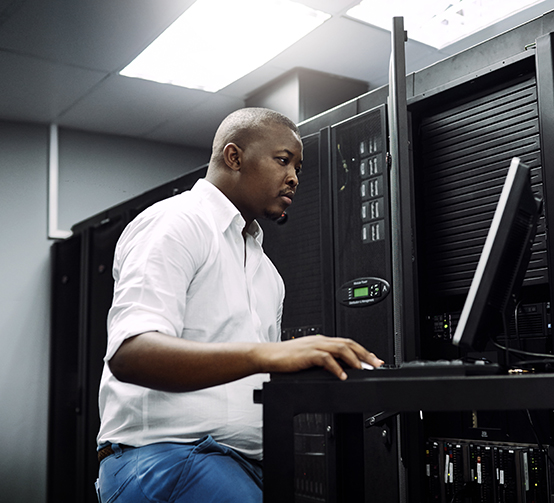 IT technician using a computer while working in the server room