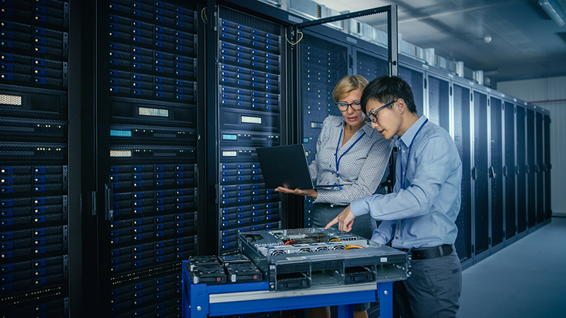 Two people working in a server room