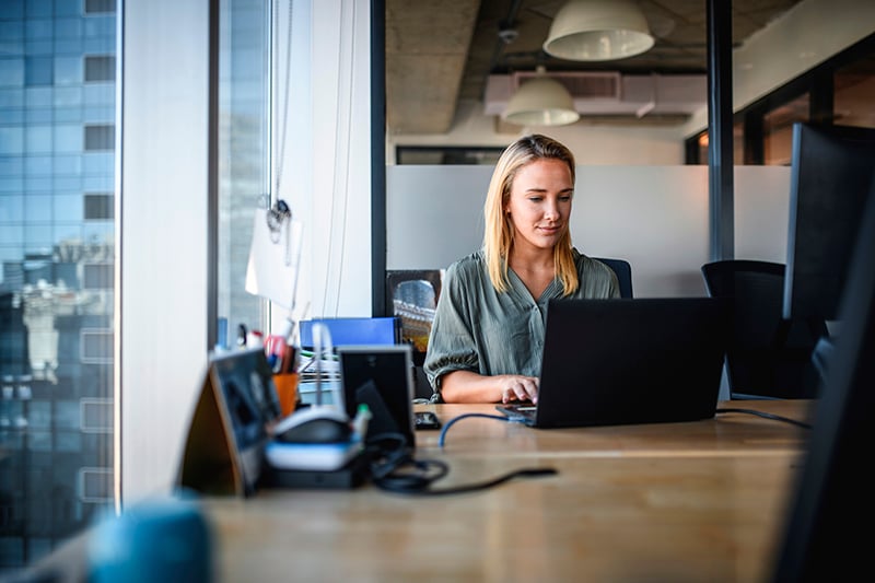 Focused Young Businesswoman Working on Laptop in Office