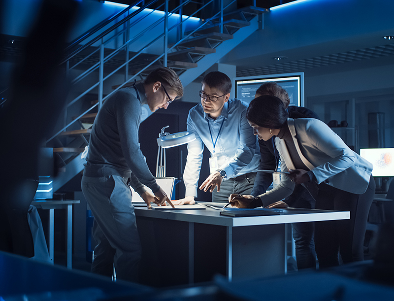 Diverse Team of Electronics Development Engineers Standing at the Desk Working with Documents