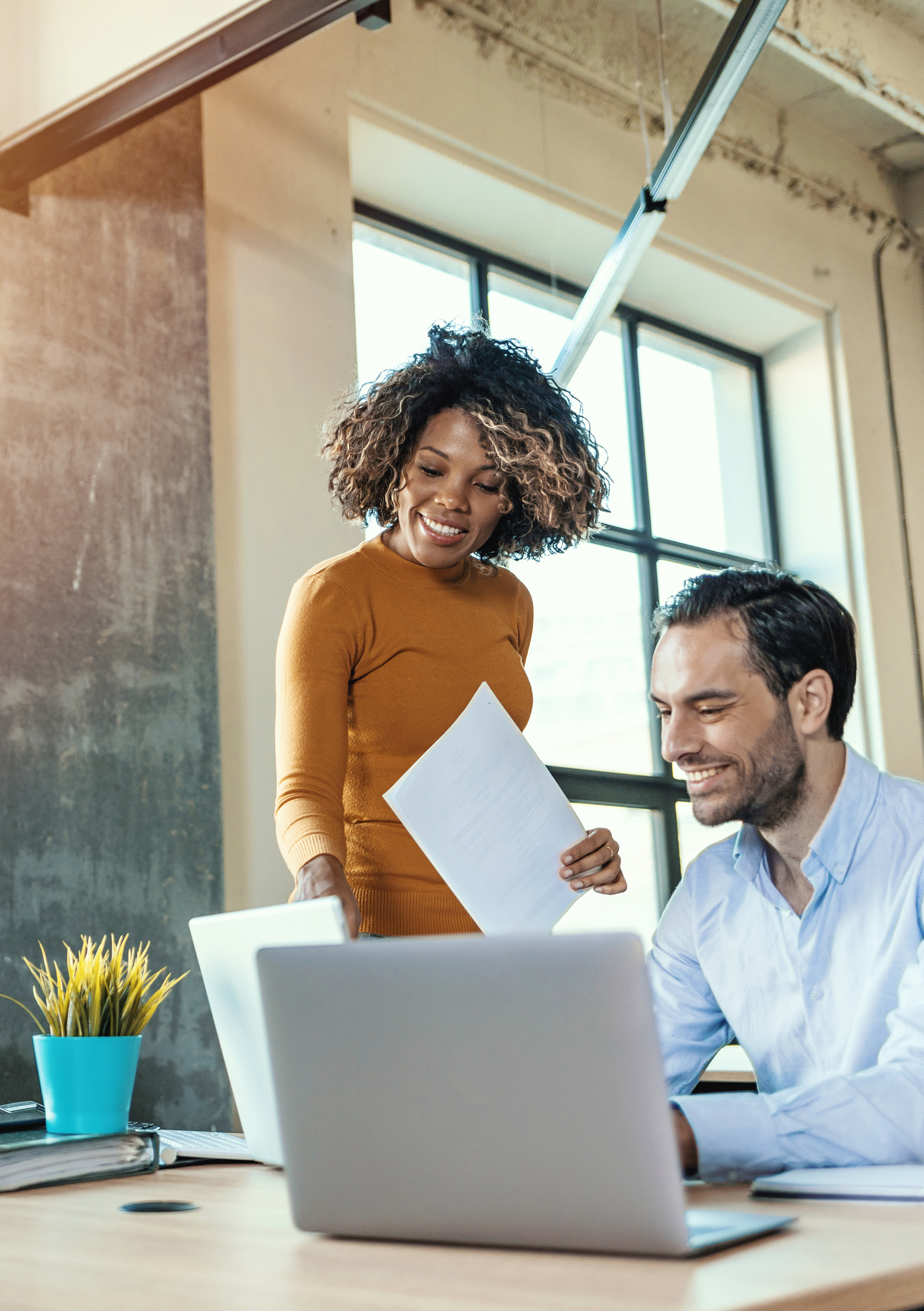 woman working, discussing something with her coworker while standing at office