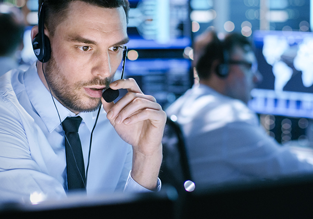 In Monitoring Room Technical Support Specialist Speaks into Headset