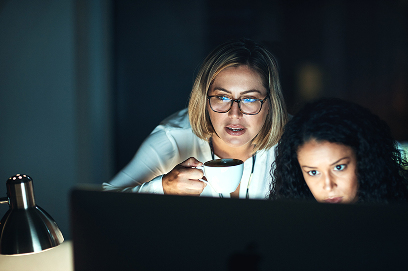 Shot of two colleagues using a computer together