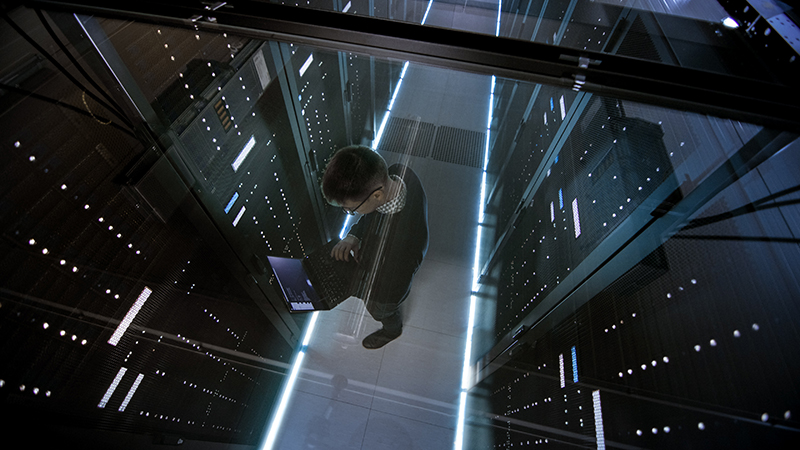 Top View Through the Glass of IT Engineer Working with Laptop